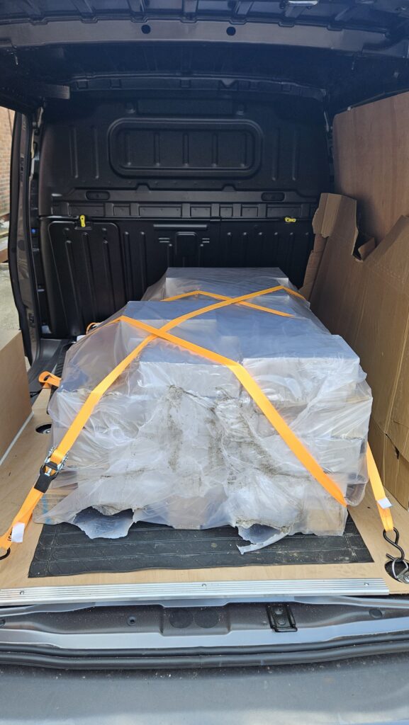 Pallet of material secured with straps inside the CamTro Transport van